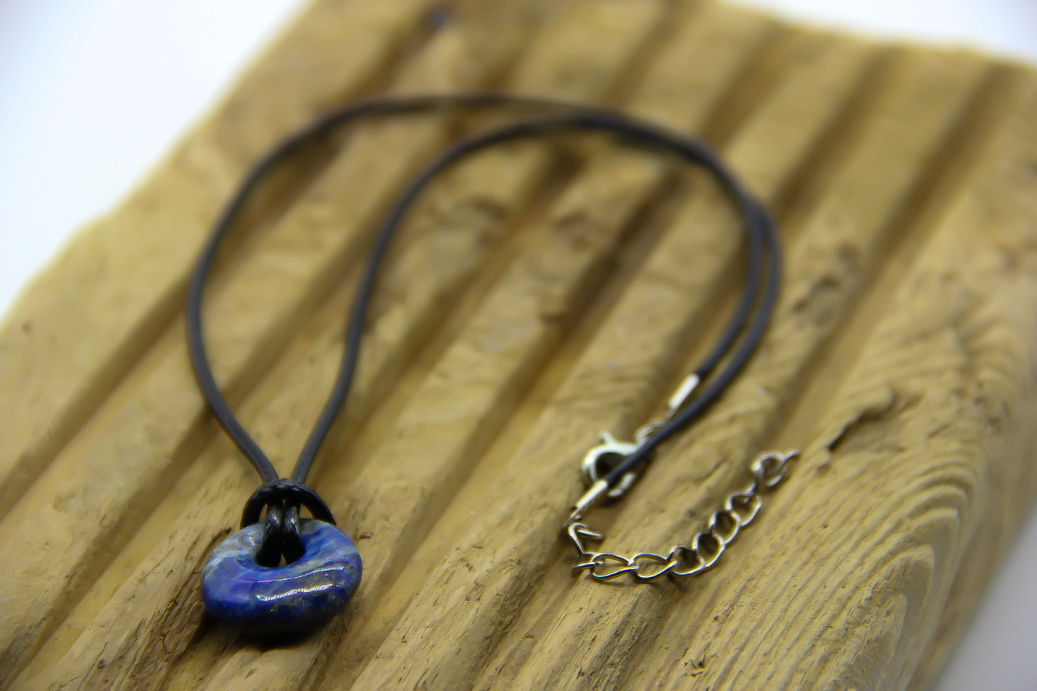 Black cord choker with circular semi-precious gemstone lapis lazuli pendant