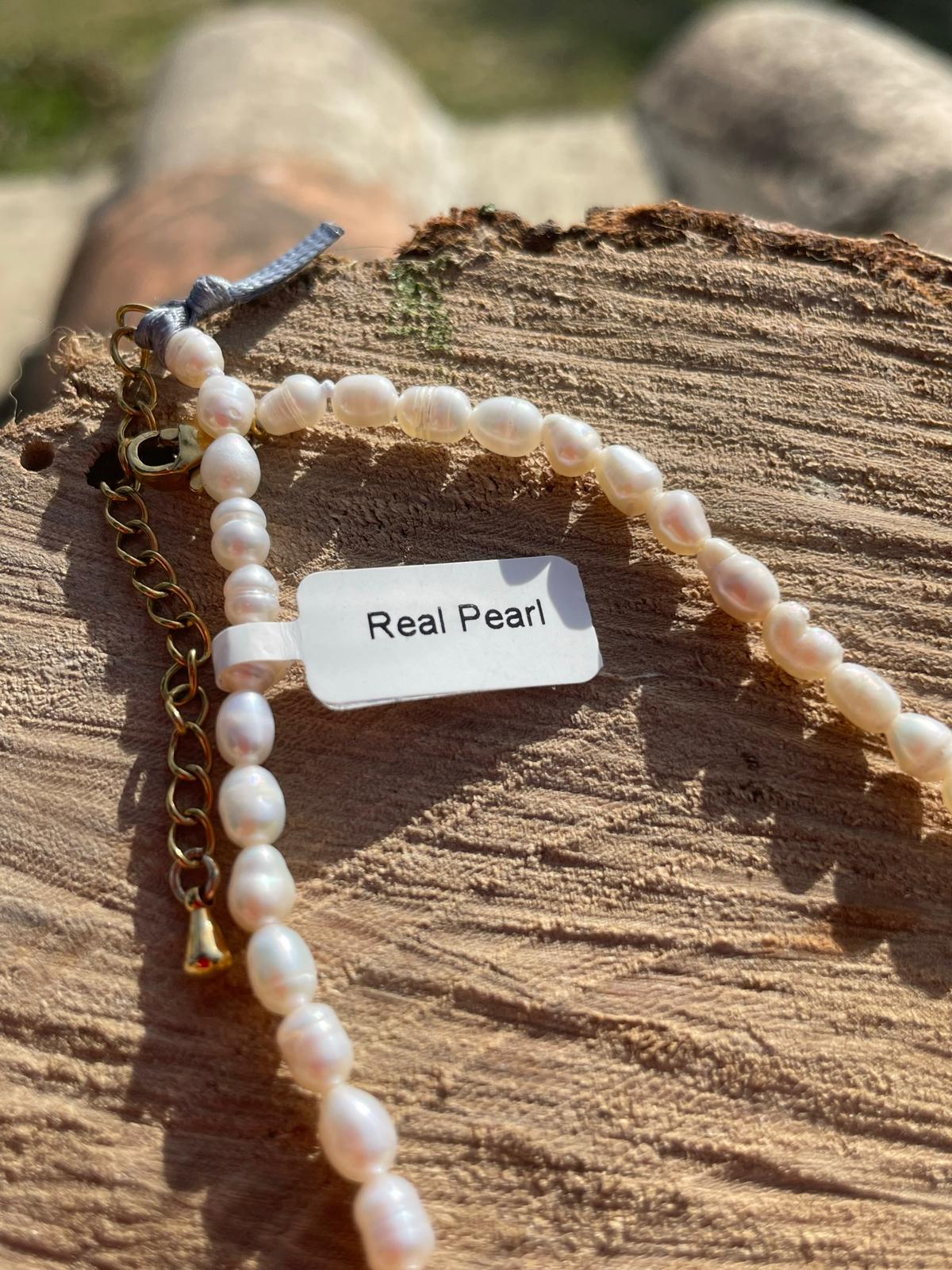 label with real pearl on it attached to a pearl necklace