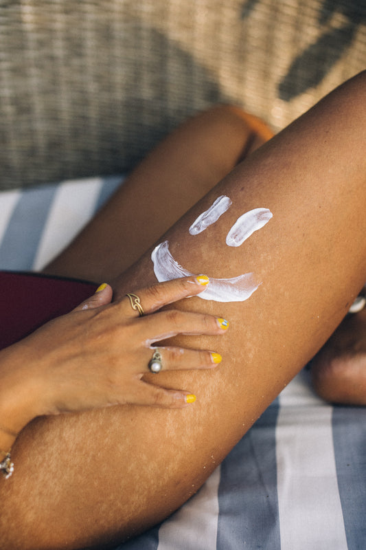 Model's thigh with sun tan lotion in the shape of a smiley face