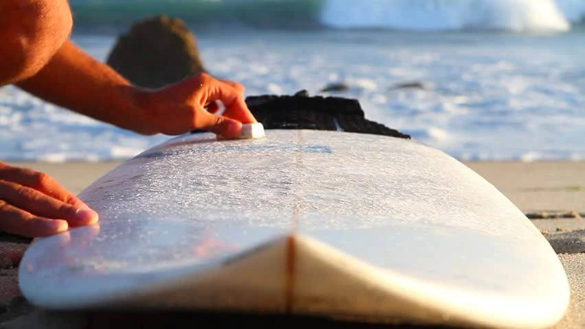 Surfer waxing surfboard - Ben's Beach Blog