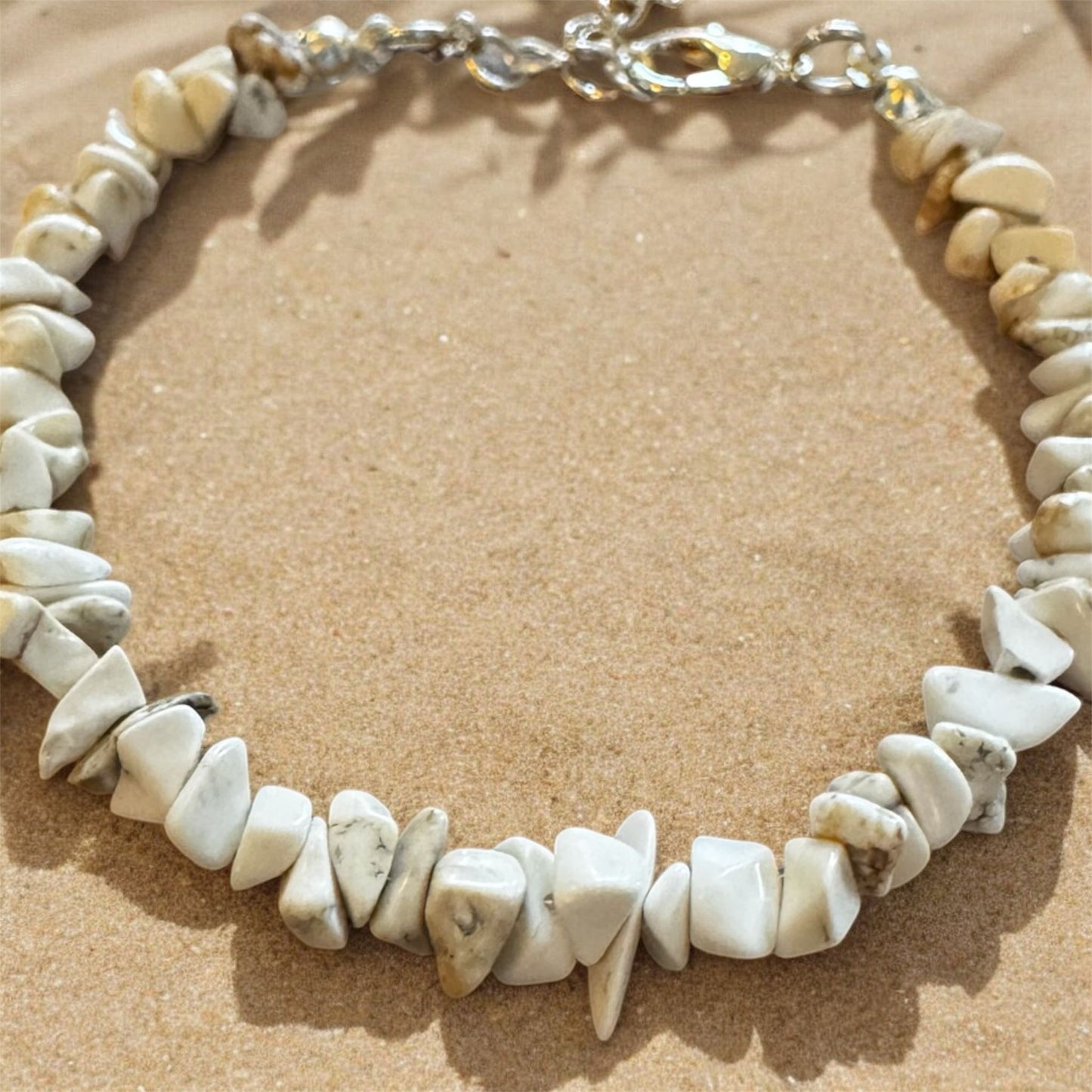 Bracelet made of stone chips and silver on a beach. 