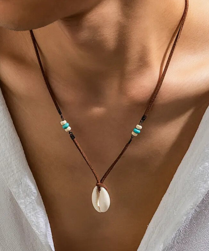 man wearing beach necklace with shell pendant