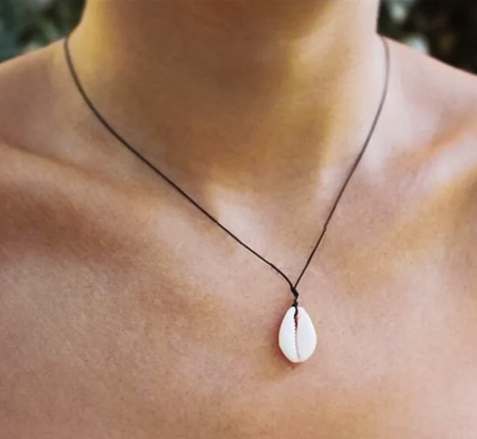 model wearing thin black necklace with white shell pendant