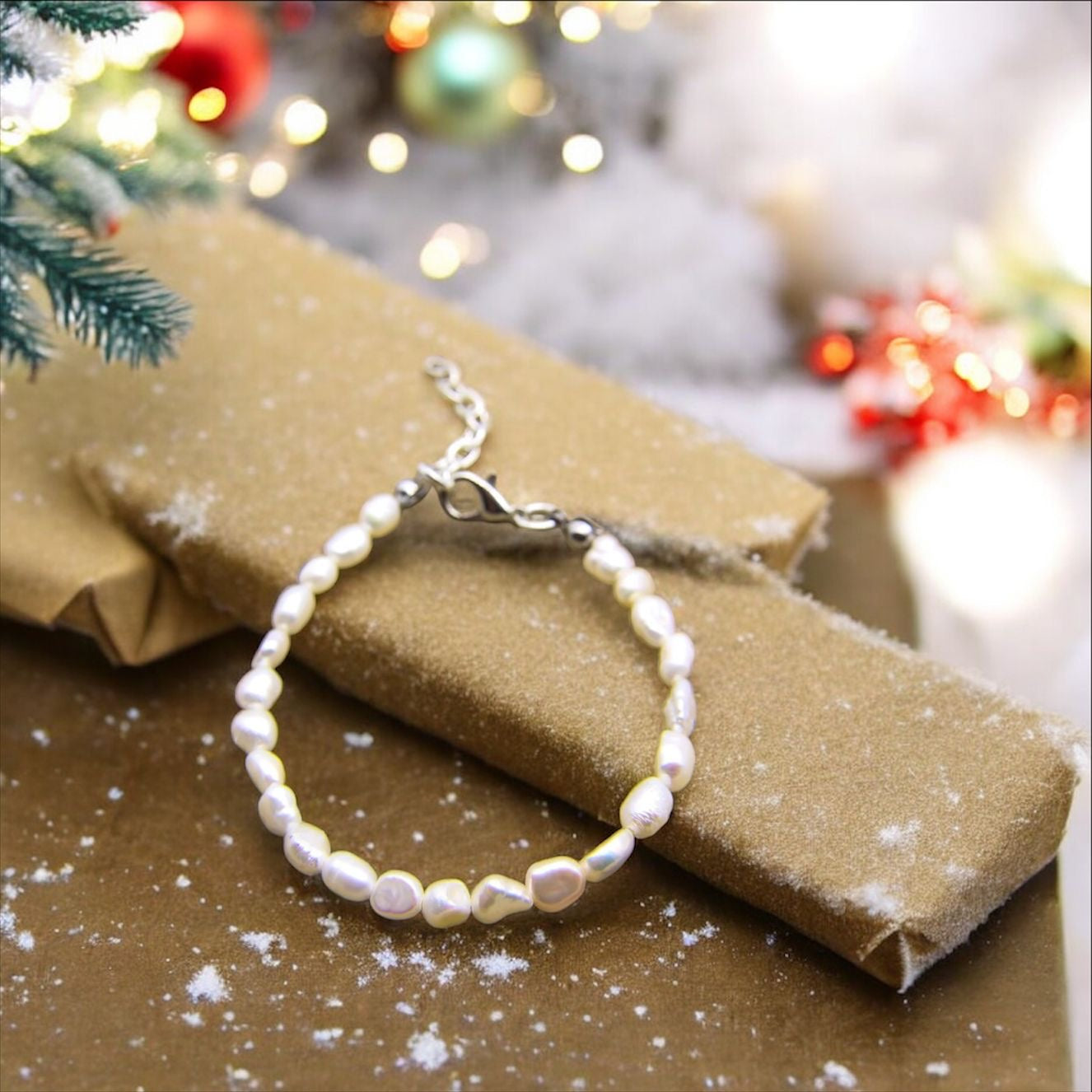 Pearl bracelet under a Christmas tree with gifts and Christmas decorations. 