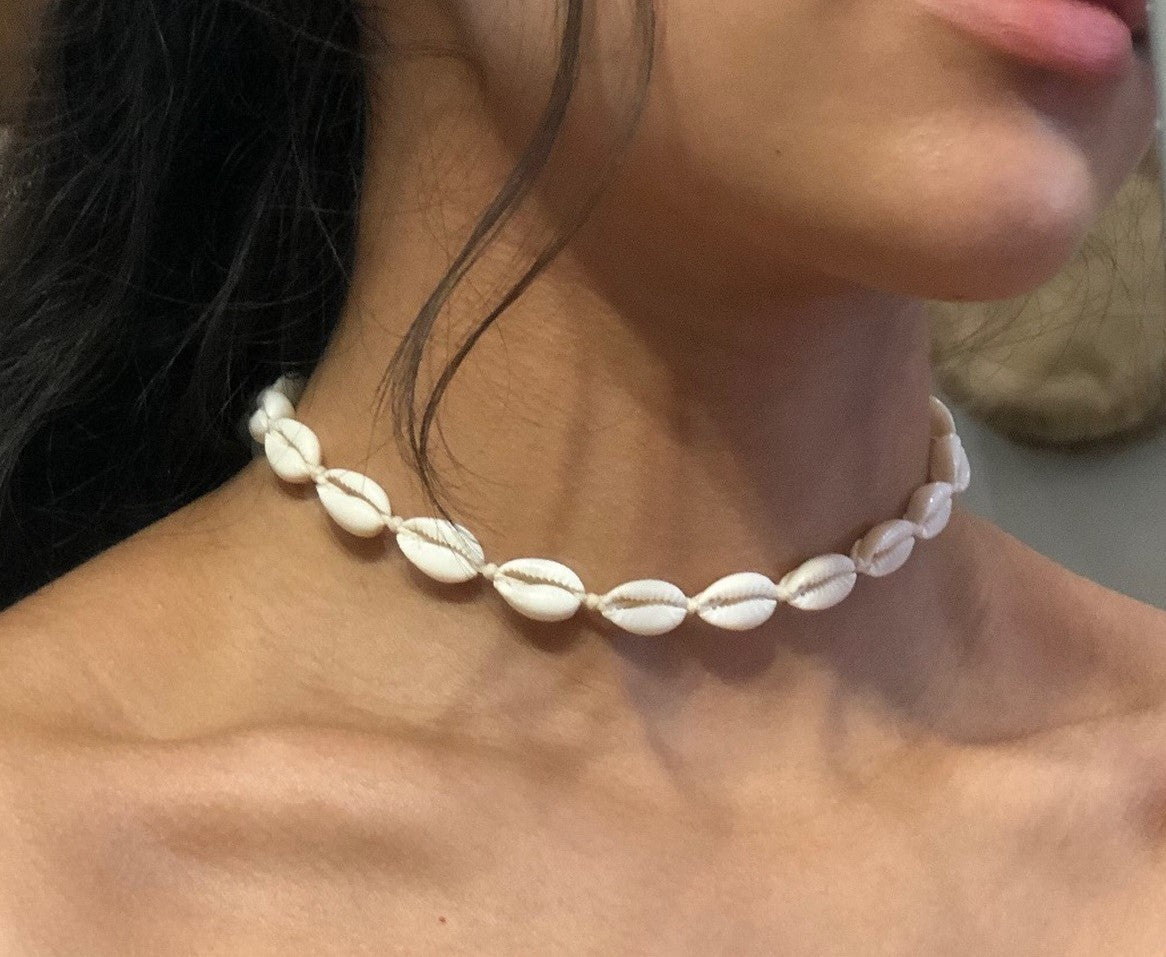 Model wearing white shell necklace