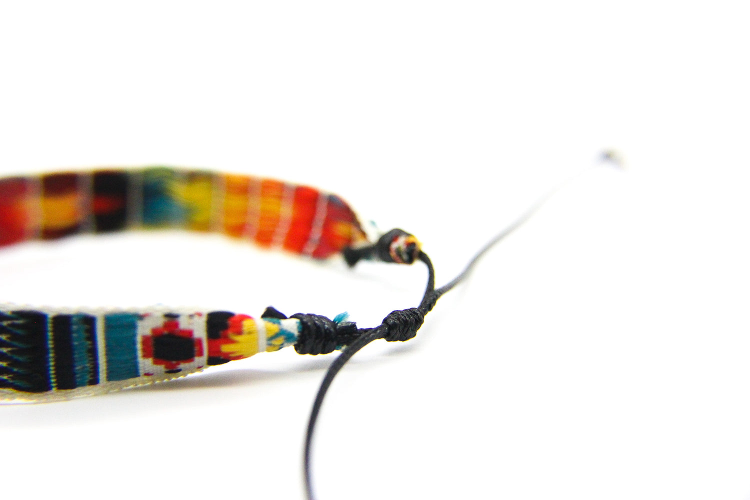 Close-up of black cotton slip-knot on a colourful friendship bracelet.