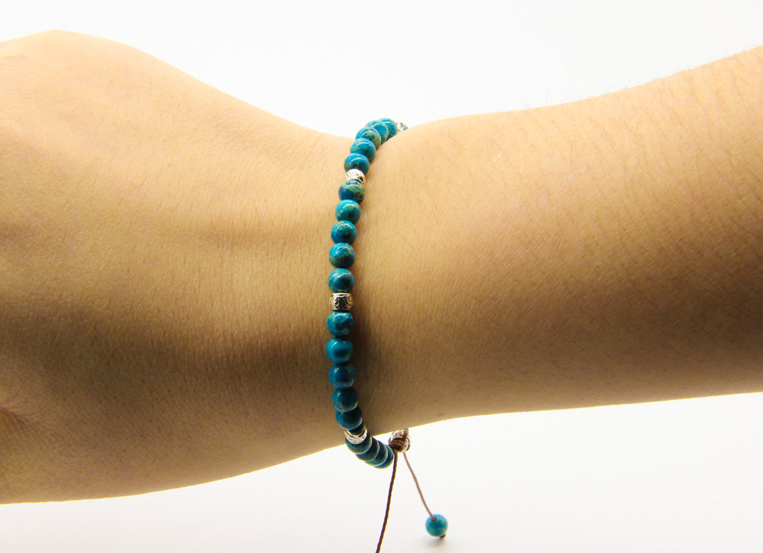 Close-up of a beaded bracelet on a model's wrist | Bracelet has blue and silver beads