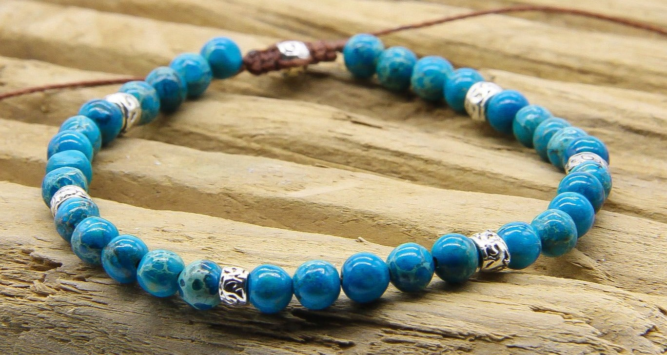 Close-up of beaded bracelet with blue and silver beads | Bracelet is on a piece of slatted wood