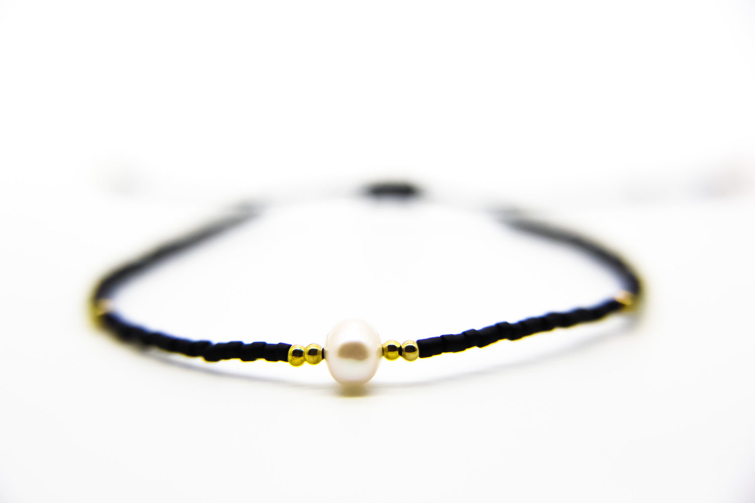 Black and gold beaded bracelet with pearl