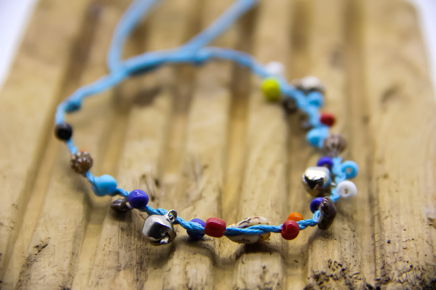 light blue beach anklet with silver bells, shells and bright coloured beads. 