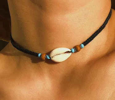 Model wearing black choker with seashell pendant and turquoise and brown beads
