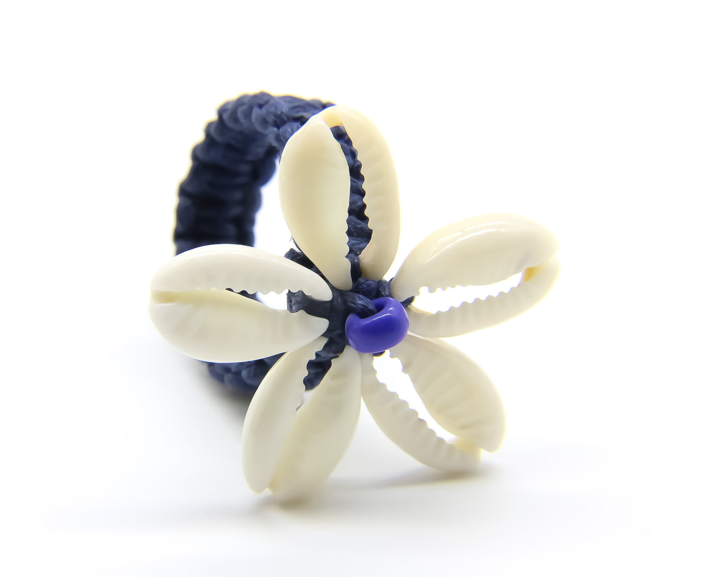 blue woven ring with cowrie shells in the shape of a flower