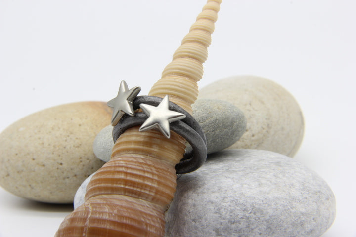 grey multi-strand ring on a seashell 