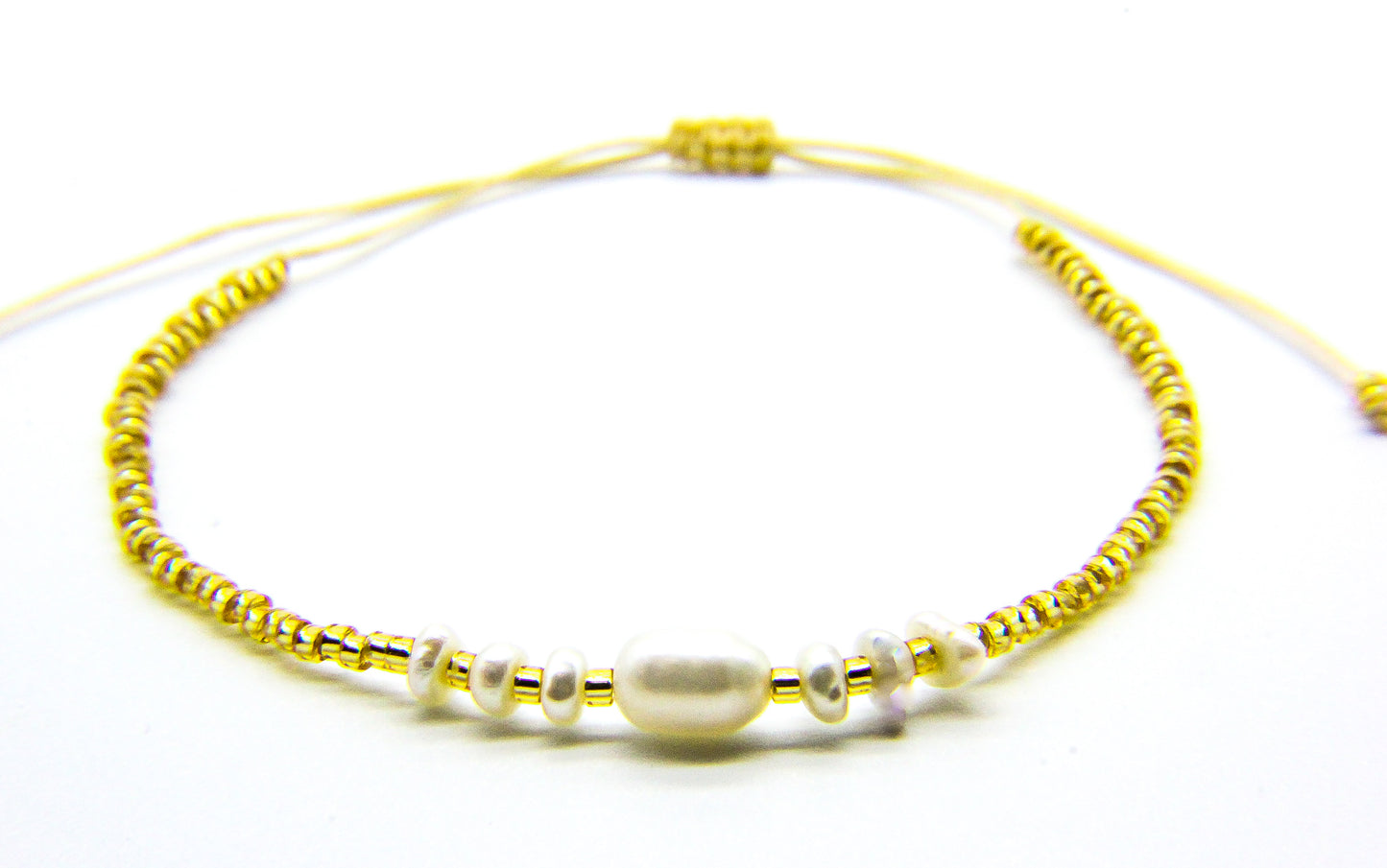 Gold Bracelet with pearls on white background 
