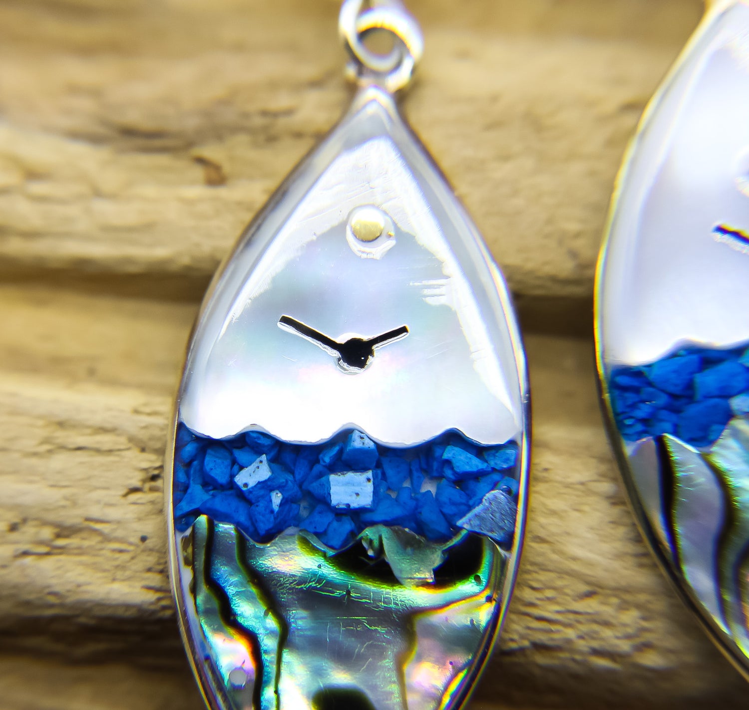 Close-up of earrings with ocean view design