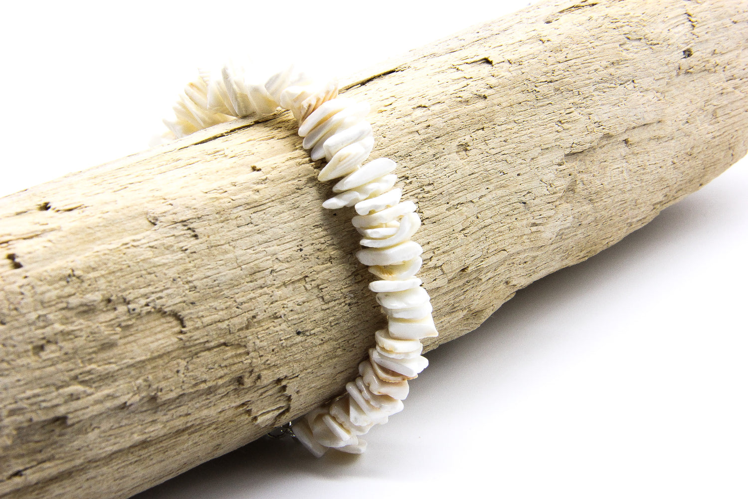 Bracelet of seashell chips displayed on driftwood | Ben's Beach