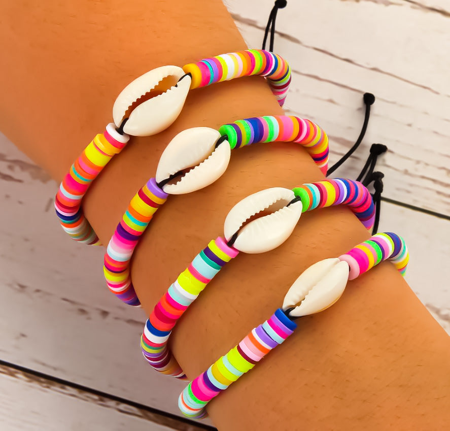 model wearing colourful rainbow bracelets with cowrie shell pendants - beach jewellery