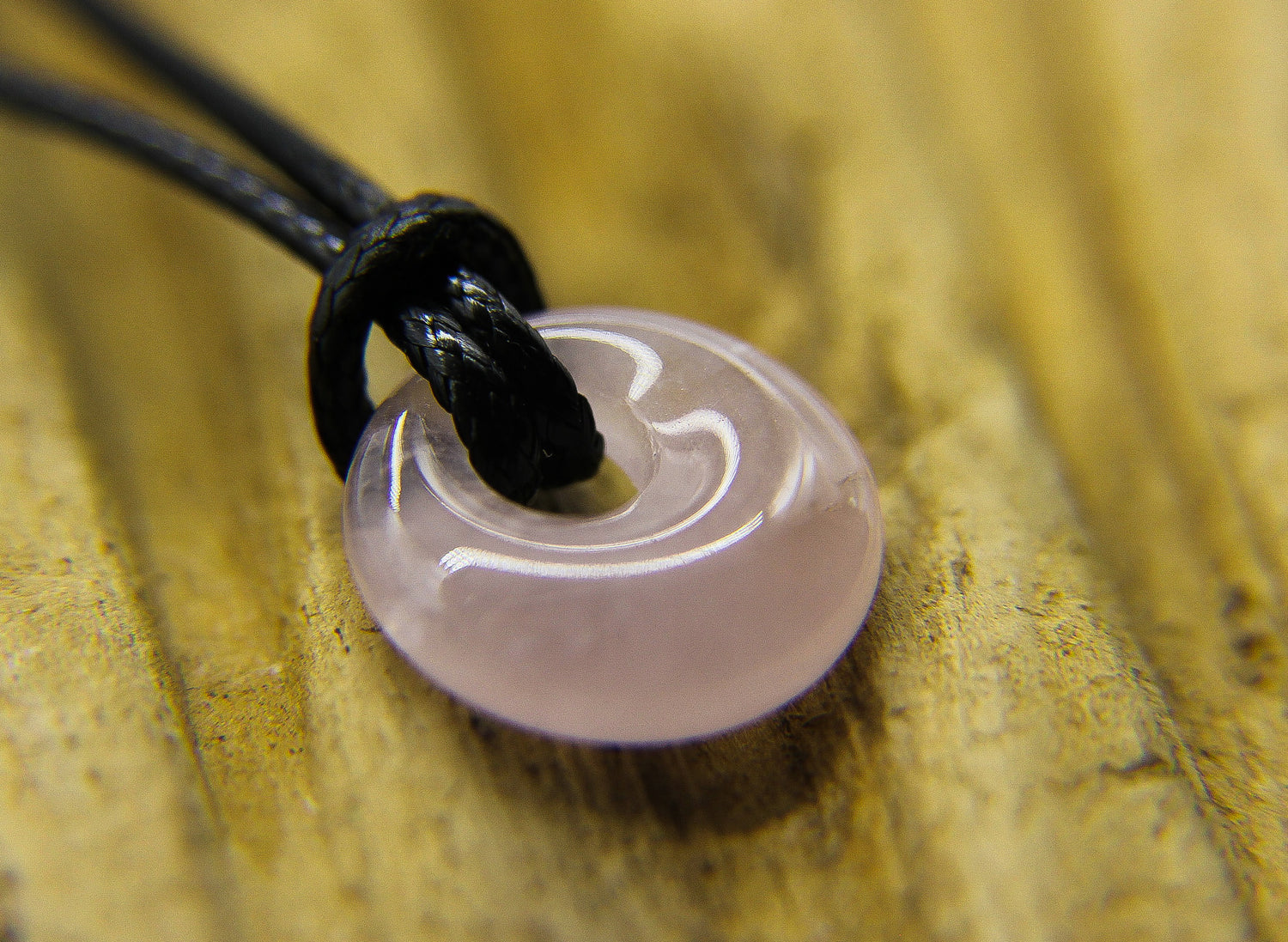 Rose quartz circular pendant on a black cord choker