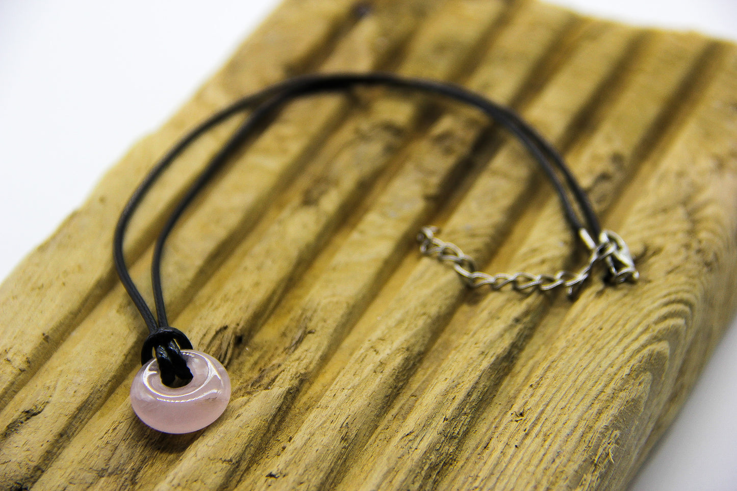 Black cord choker with pink quartz pendant. 