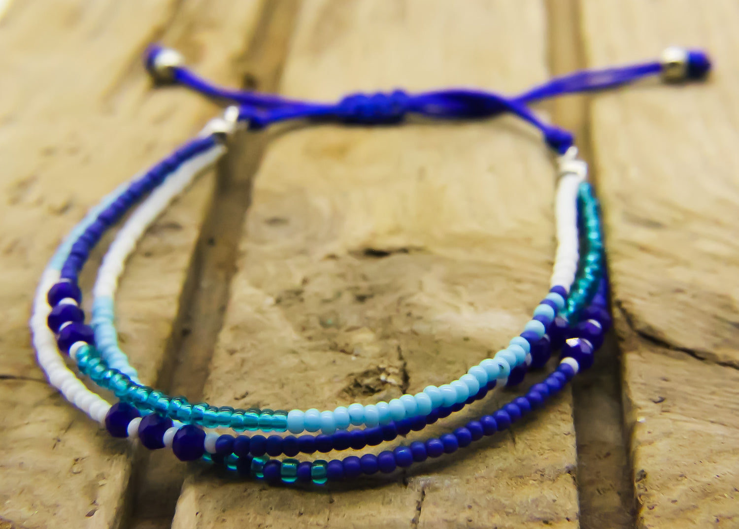 Anklet of blue and white beads on a piece of driftwood