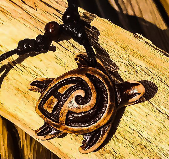 Close up of carved sea turtle pendant on a piece of wood