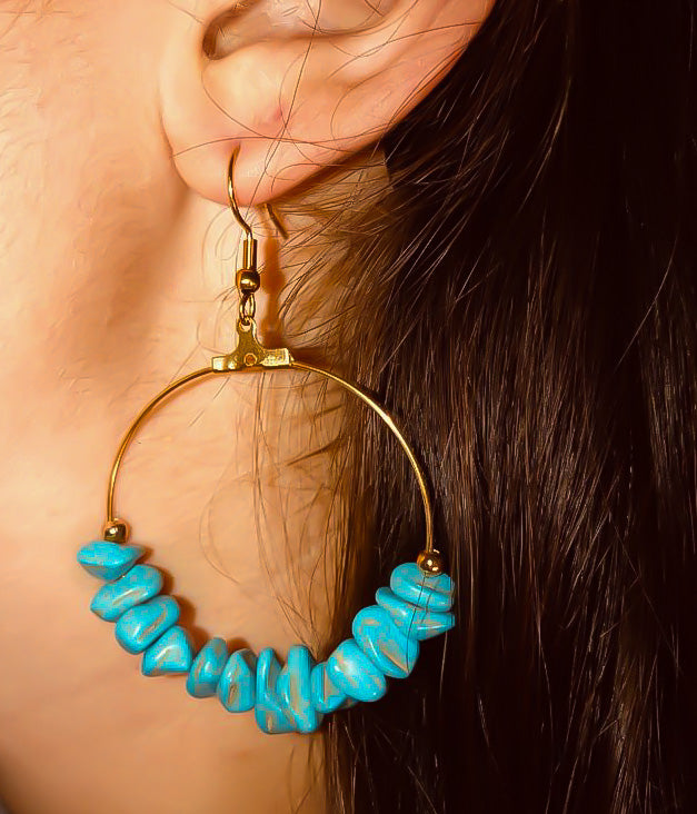Large hoop earring on a model's ear with irregular turquoise stones