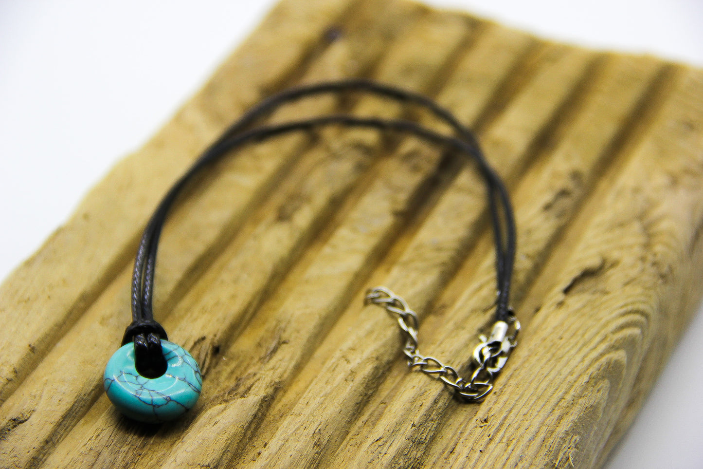 Turquoise pendant on a black cord necklace. 