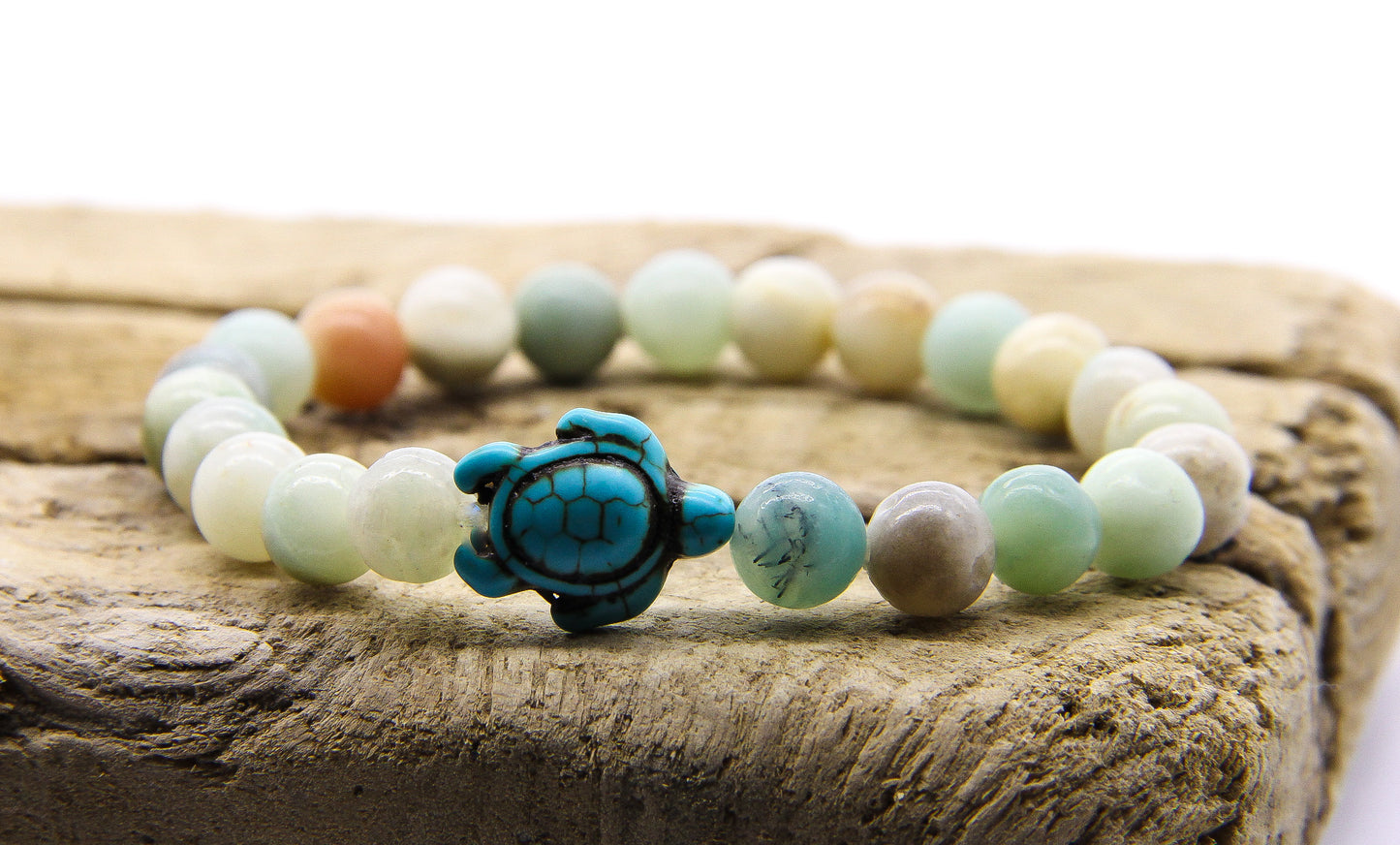 amazonite beaded bracelet with turquoise turtle pendant displayed on a piece of wood